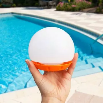 Hand holding Daily Dose Dispenser with swimming pool in the background