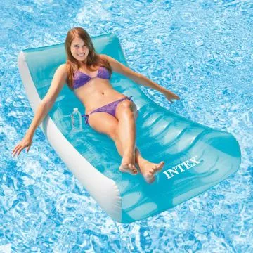Intex Rockin' Lounge - A smiling woman in a purple bikini reclines on a translucent blue and white inflatable pool float, holding a water bottle, in a swimming pool. The "INTEX" logo is visible on the float.