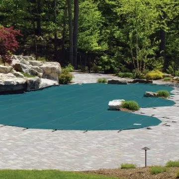 Overhead view of a MeycoLite safety cover installation showing the perimeter strap alignment and recessed brass anchors on a concrete pool deck.