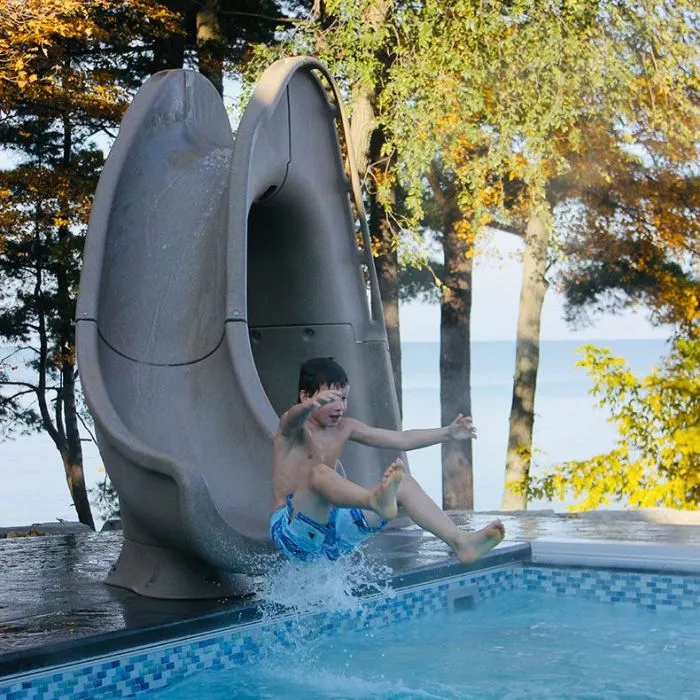 Global Pool Products Tidal Wave Inground Pool Slide, Right Turn, Sandstone | lifestyle image Global Pool Products Tidal Wave Inground Pool Slide, Right Turn, Sandstone | lifestyle image