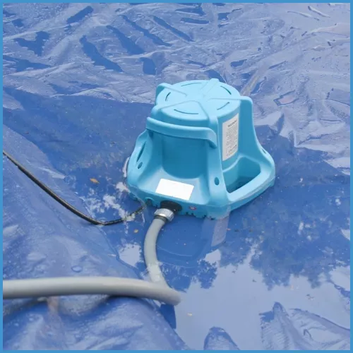 A cover pump removing standing water from a pool cover before opening the pool.